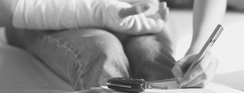 Person with injured arm signing a legal settlement offer document.