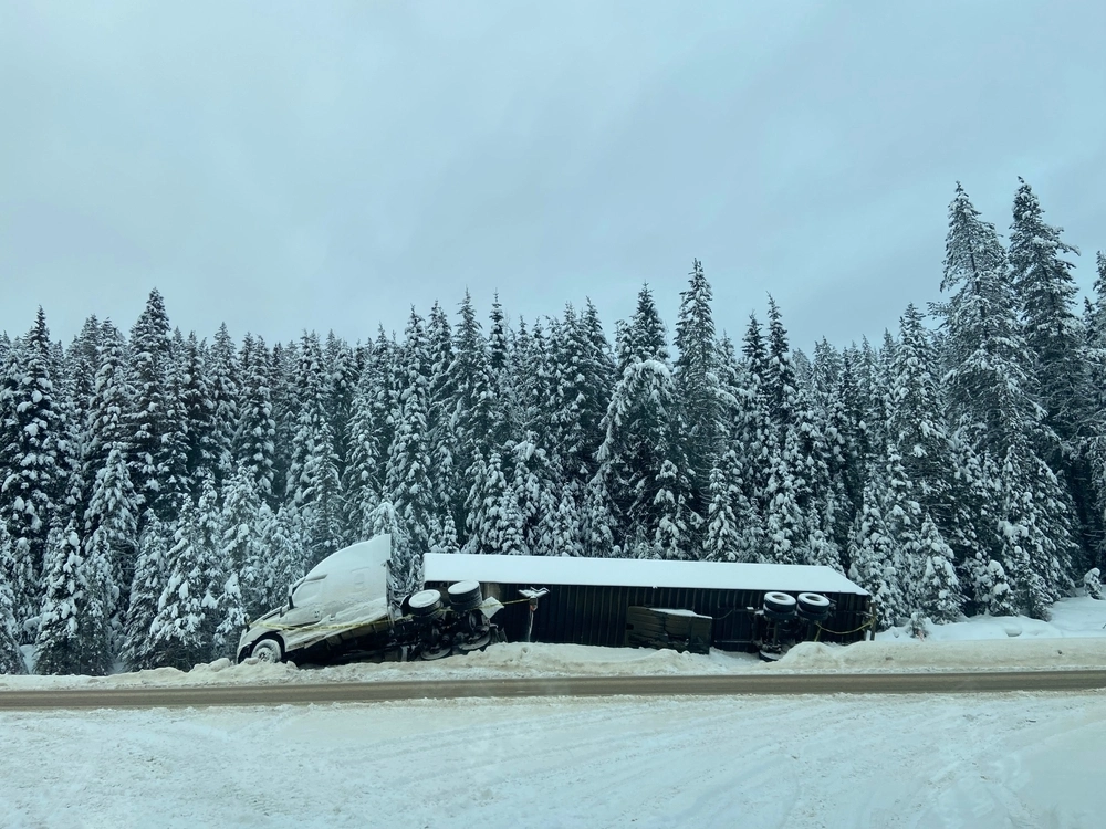 Jackknifed semi-truck accident on a snowy winter road.